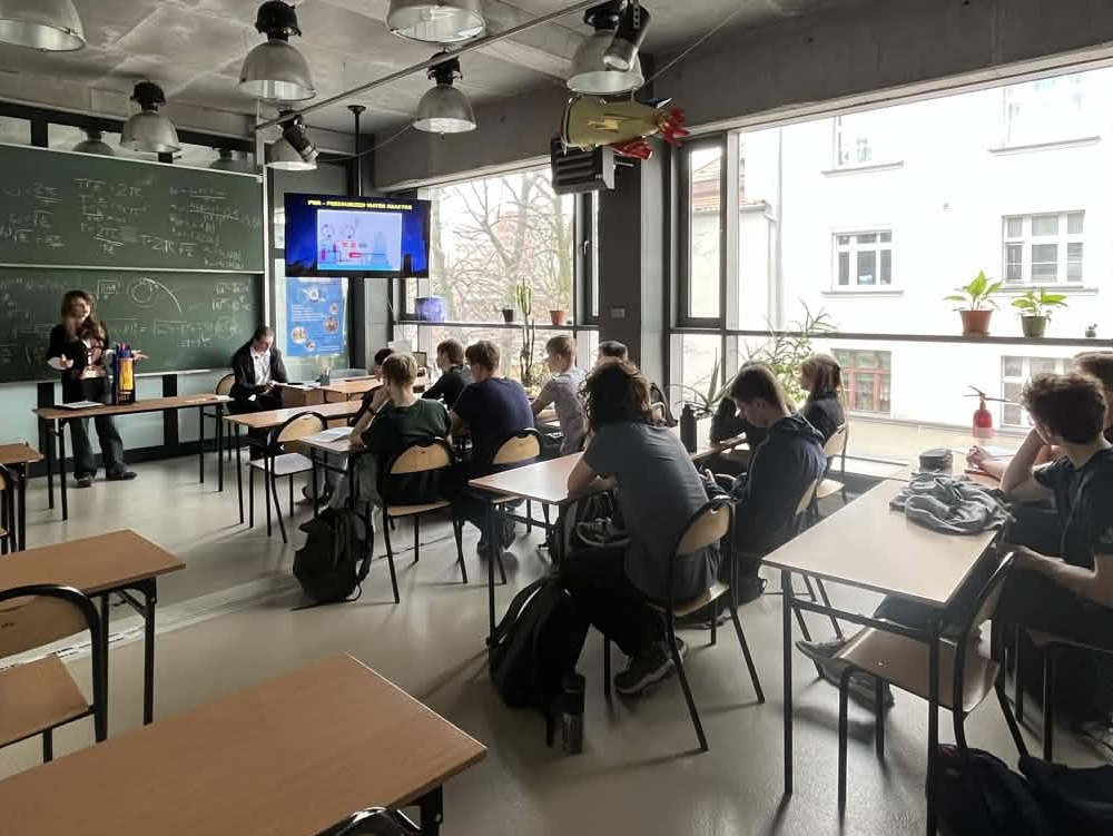 Sala pełna uczniów. Oliwia Fink przedstawia model reaktora.